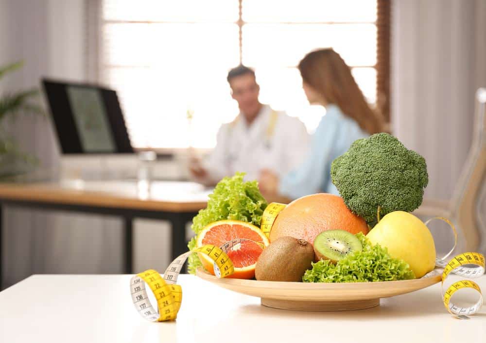 What Is A Clinical Nutritionist? 1 A bowl filled with assorted fruits and vegetables placed on a wooden table.