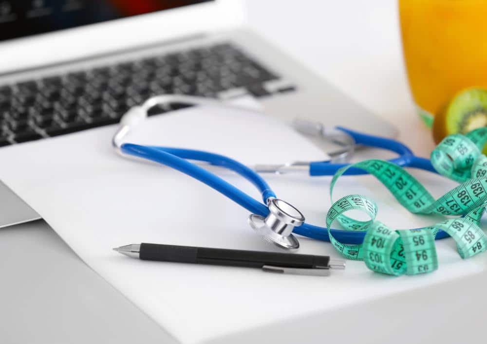 What Is A Clinical Nutritionist? 4 A stethoscope, measuring tape, and notebook arranged on a desk, suggesting a health or fitness-related context.