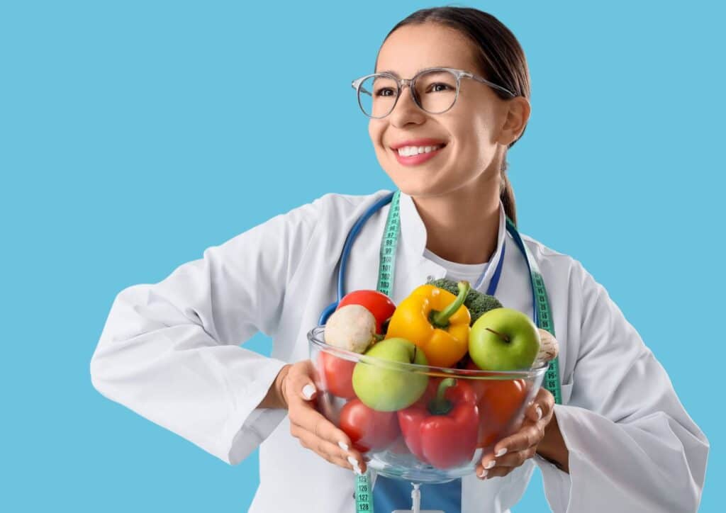 What Is A Weight Loss Nutritionist? 7 A woman in a white coat holds a bowl filled with colourful fruits and vegetables, promoting healthy eating.