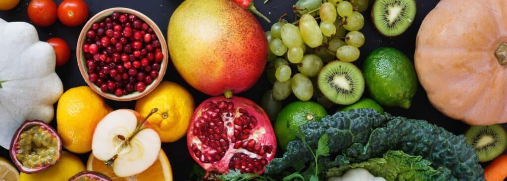 What Is School Wellbeing? 5 A colourful assortment of fruits and vegetables displayed on a black surface, showcasing their vibrant colors and textures.