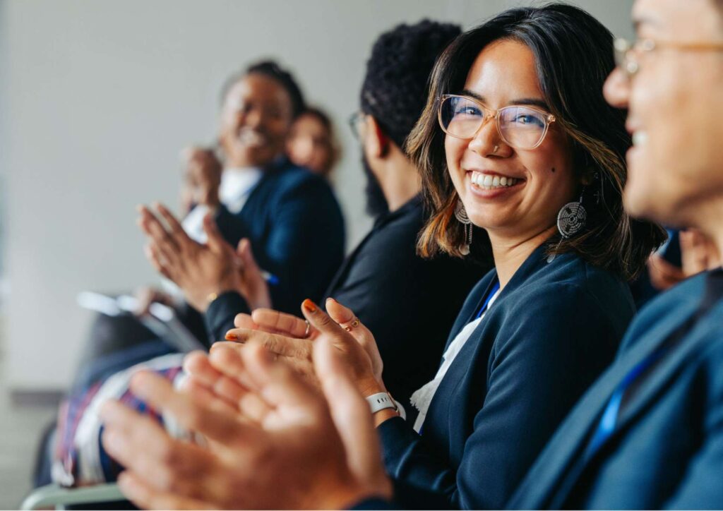 What Is Corporate Nutrition? 1 A diverse group of people clapping enthusiastically in a conference room setting.