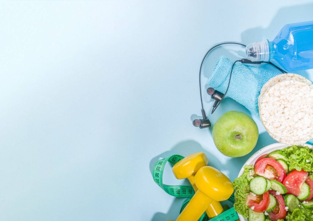 What Is The Perfect Diet? 3 A bowl of healthy food alongside a bottle of water and dumbbells, promoting fitness and nutrition.