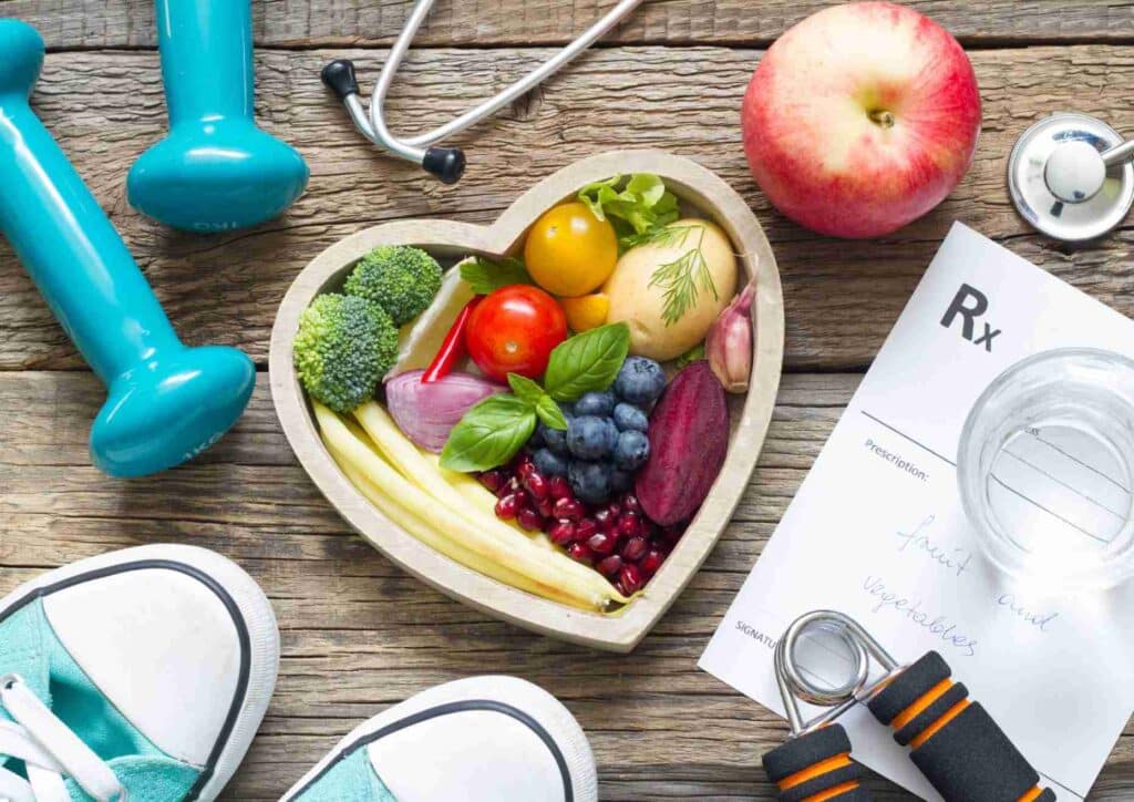 What Is The Perfect Diet? 5 Heart-shaped bowl filled with fruits and vegetables, accompanied by a stethoscope and a prescription pad.
