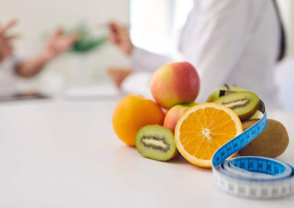 What Does a Nutritionist Do? 7 A woman measures an orange with a measuring tape, focusing on the fruit's size and dimensions.