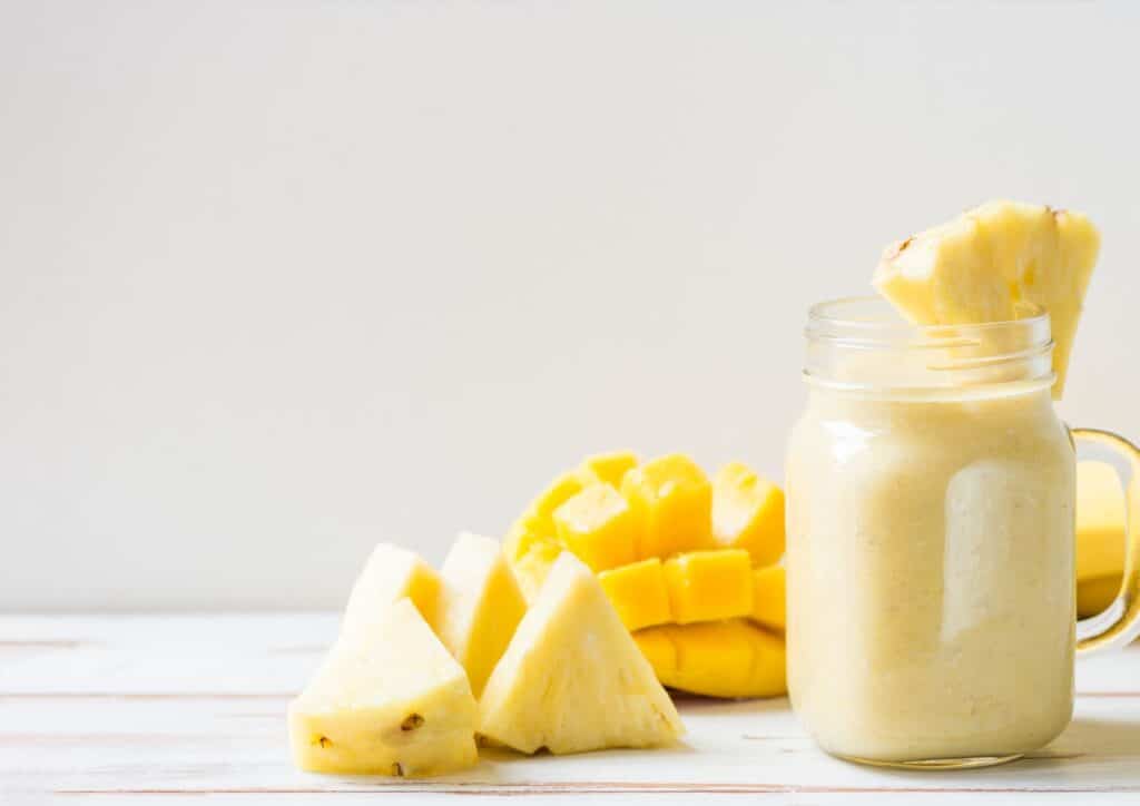 High Protein Banana Smoothie For Weight Loss 8 A refreshing pineapple smoothie garnished with fresh pineapple slices on the rim of the glass.