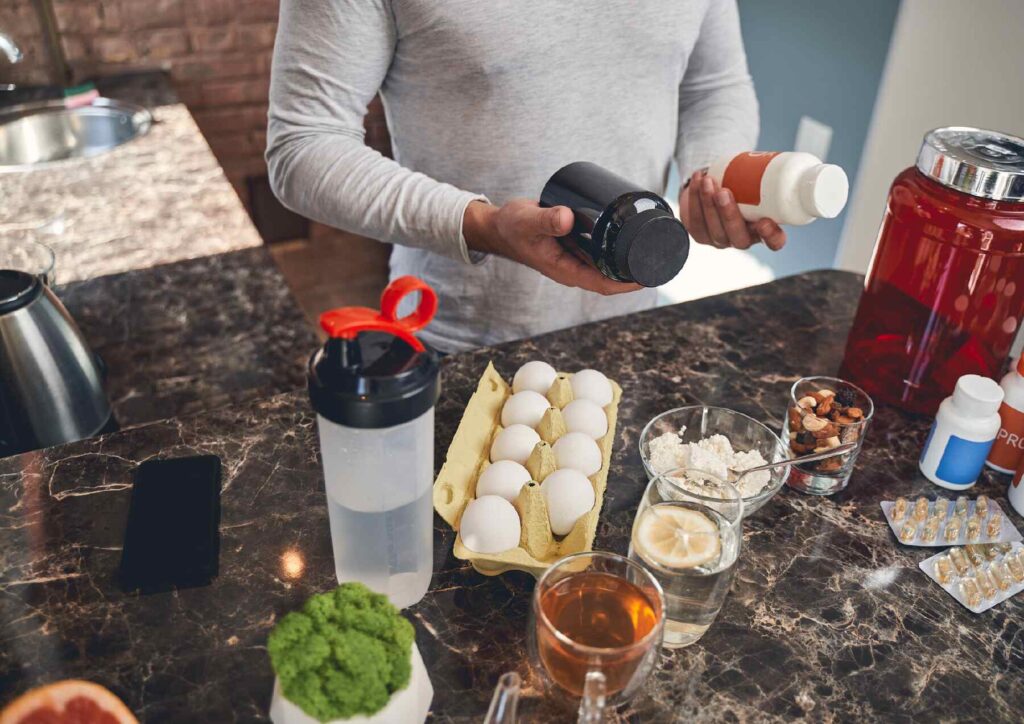 What Is A Sports Nutritionist? 4 A man holds a bottle of vitamins and supplements, showcasing his commitment to health and wellness.
