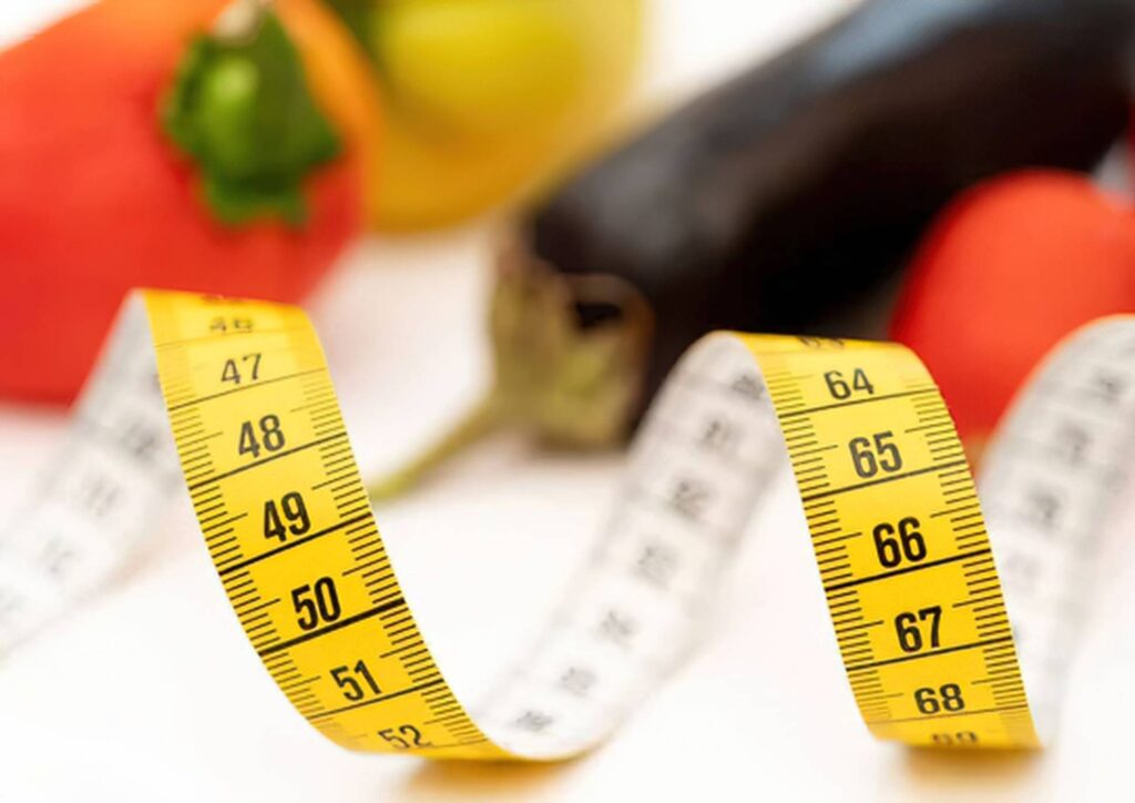 How Much Does a Weight Loss Nutritionist Cost in Sydney? 5 A measuring tape encircles a variety of fresh vegetables, symbolising health and nutrition.