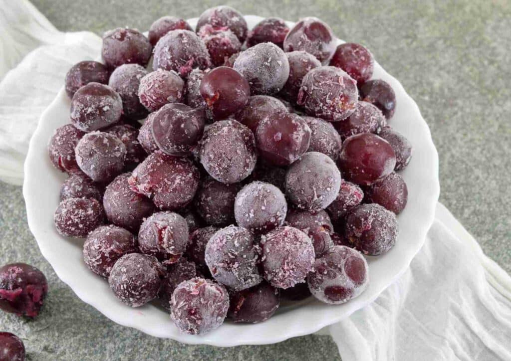 Are Grapes Good for Weight Loss? 3 A bowl of red frozen grapes in a white bowl.