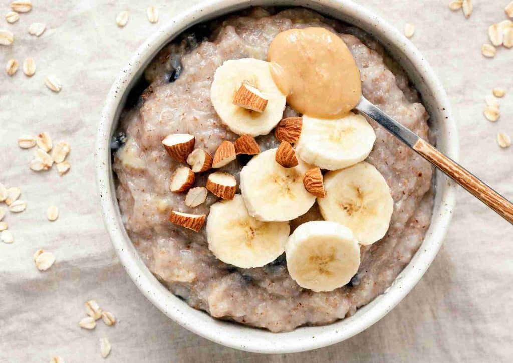 Are Oats Good for Weight Loss? 7 A bowl of oatmeal topped with peanut butter and sliced banana, showcasing a nutritious breakfast option.