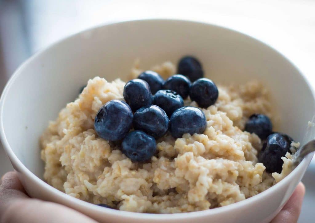 Are Oats Good for Weight Loss? 10 A bowl of blueberry oatmeal topped with fresh blueberries and oats, showcasing a nutritious breakfast option.