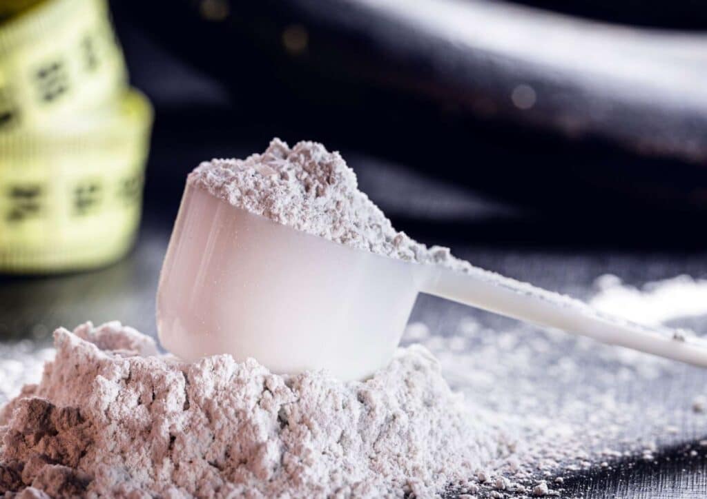 Is Creatine Good for Weight Loss? 9 A measuring tape lies next to a scoop filled with powder, indicating precise measurement for a task or recipe.