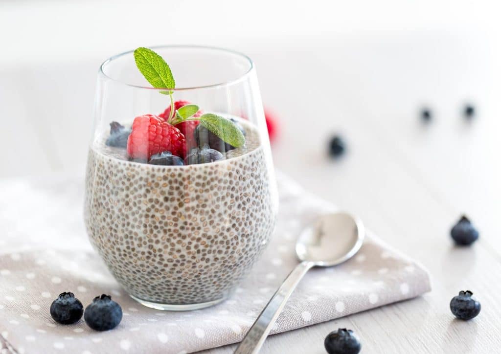Do Chia Seeds Help With Weight Loss? 6 Chia pudding topped with fresh berries and mint leaves, served in a clear glass bowl.