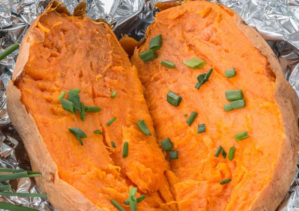 Is Sweet Potato Good for Weight Loss? 7 A baked sweet potato topped with chopped green onions, showcasing a warm, inviting dish.