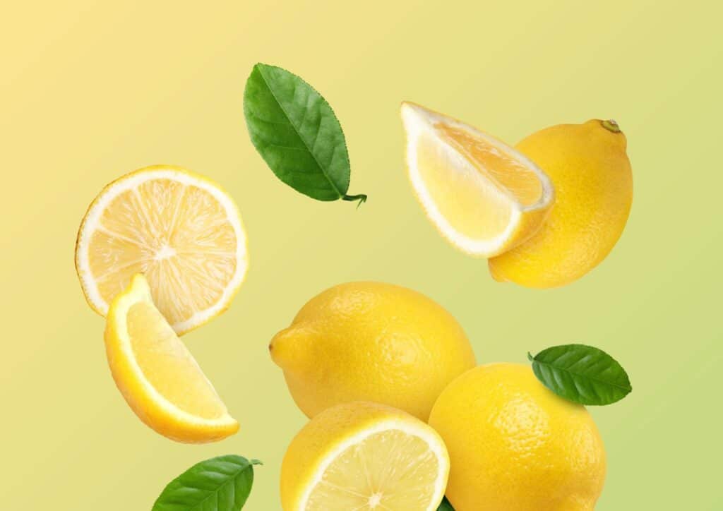 Does Lemon Water Help With Weight Loss? 6 Freshly squeezed lemon juice in a glass, surrounded by whole lemons on a wooden surface.