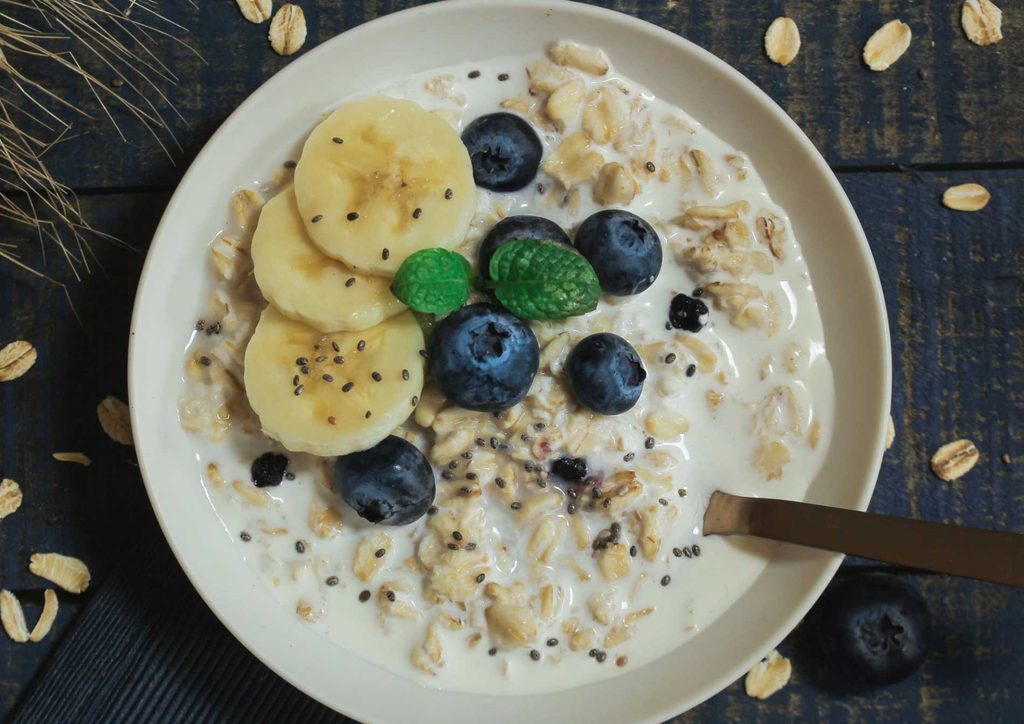 Are Oats Good for Weight Loss? 8 A bowl of oatmeal topped with fresh blueberries and sliced bananas.