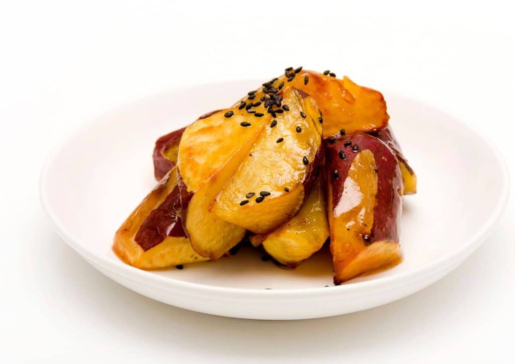 Is Sweet Potato Good for Weight Loss? 15 A plate of cooked potatoes garnished with sesame seeds, showcasing a simple yet appealing dish.