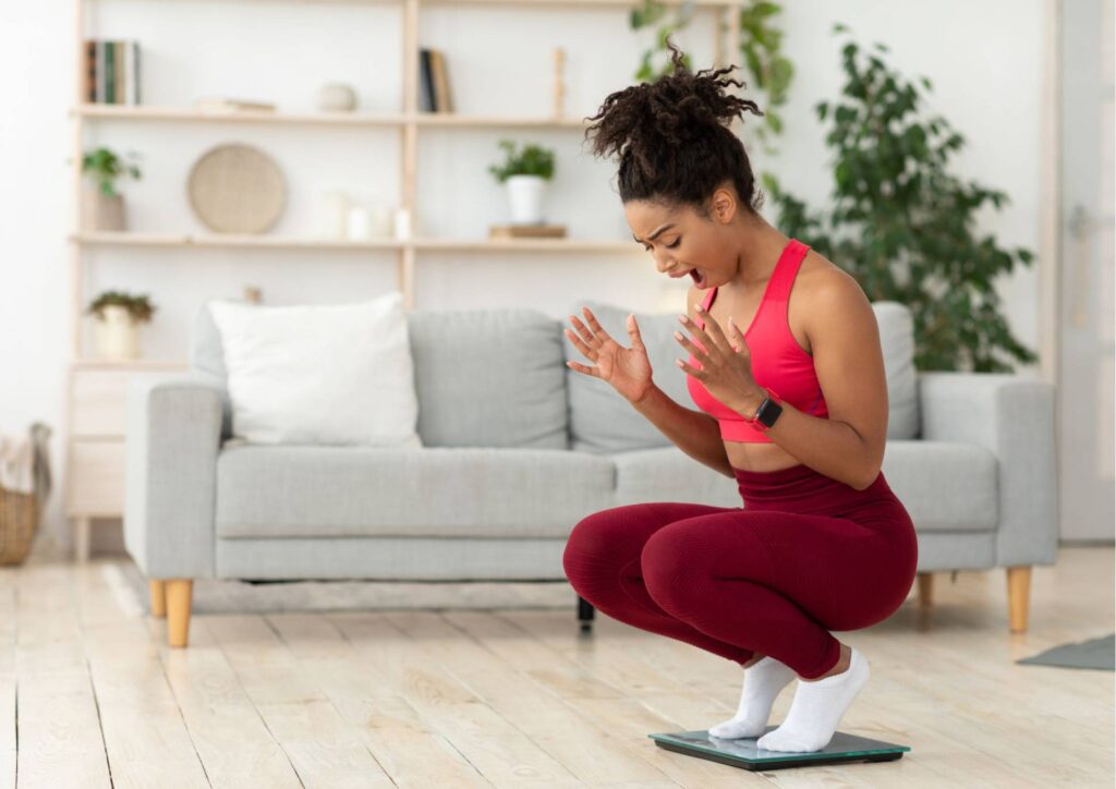 Is Creatine Good for Weight Loss? 4 A woman squats on a balance board in her living room, demonstrating balance and strength training.
