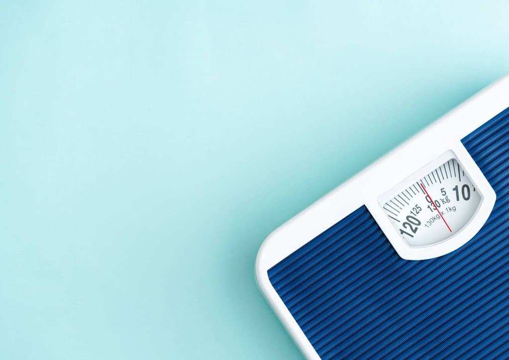 How to Break a Weight Loss Plateau, a Nutritionist's Approach 15 A weight scale displayed against a blue background, emphasizing its sleek design and functionality.