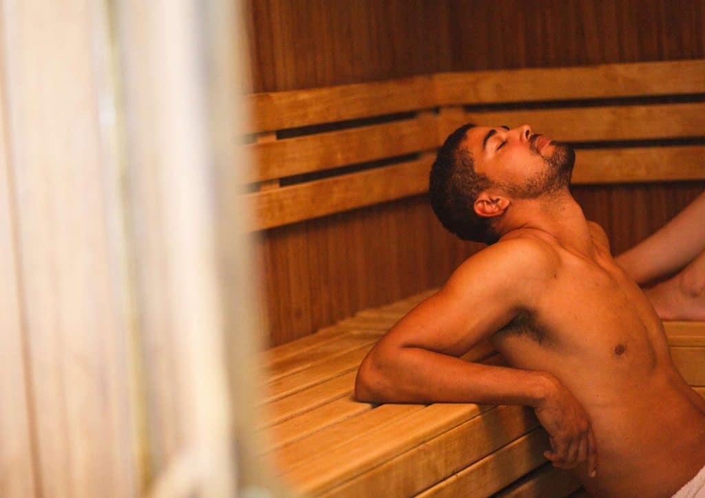 Do Saunas Help With Weight Loss? What Actually Happens 8 A man and woman relax together in a wooden sauna, surrounded by steam and warm lighting.