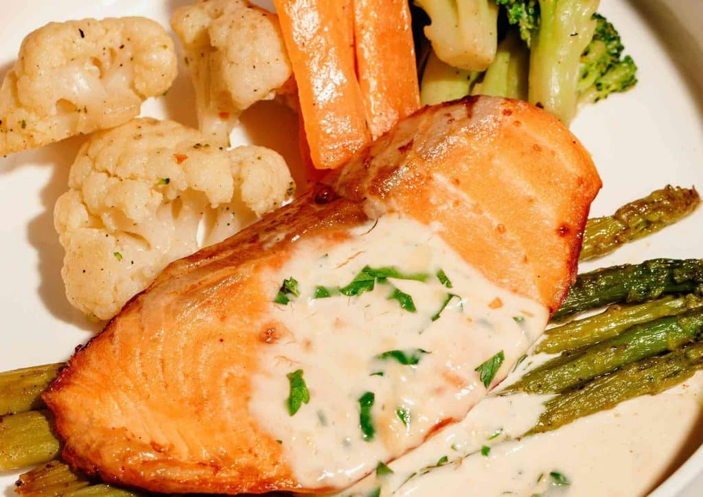 Is Sweet Potato Good for Weight Loss? 22 A plate featuring grilled salmon, steamed asparagus, and broccoli arranged artfully for a nutritious meal.