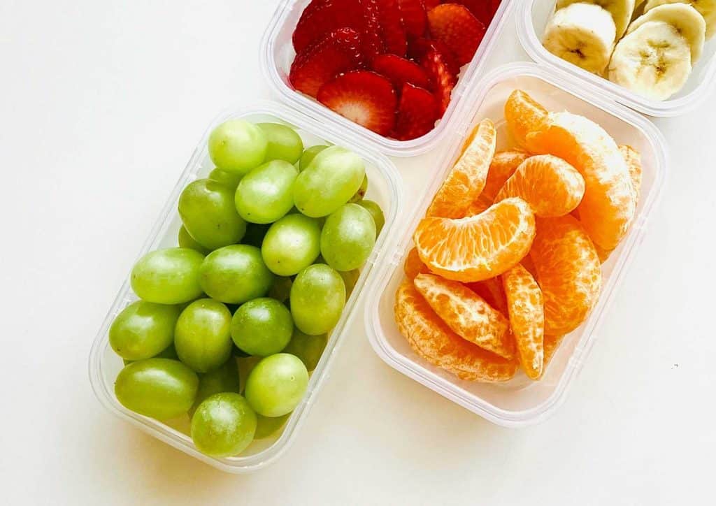 The Best Foods for Weight Loss 3 Three plastic containers filled with assorted fruits, including bananas, arranged on a flat surface.