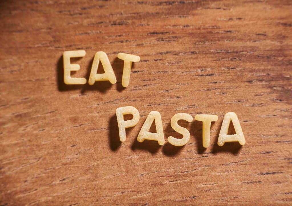 Is Pasta Good for Weight Loss? 2 A wooden table features the words "Eat Pasta," highlighting a focus on Italian cuisine.