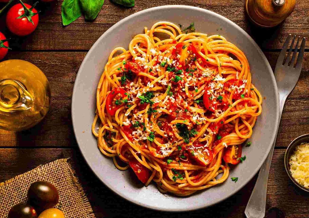 Is Pasta Good for Weight Loss? 7 plate of spaghetti topped with rich tomato sauce and sprinkled with grated parmesan cheese.