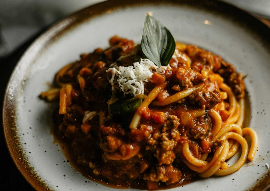 Is Pasta Good for Weight Loss? 12 A vibrant street scene featuring various Italian dishes displayed at outdoor cafes in a bustling city setting.