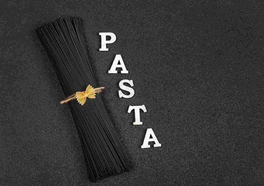 Is Pasta Good for Weight Loss? 15 A close-up of uncooked pasta arranged artistically on a black background.