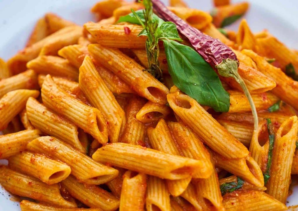 Is Pasta Good for Weight Loss? 17 A bowl of penne pasta topped with rich tomato sauce and fresh basil leaves.