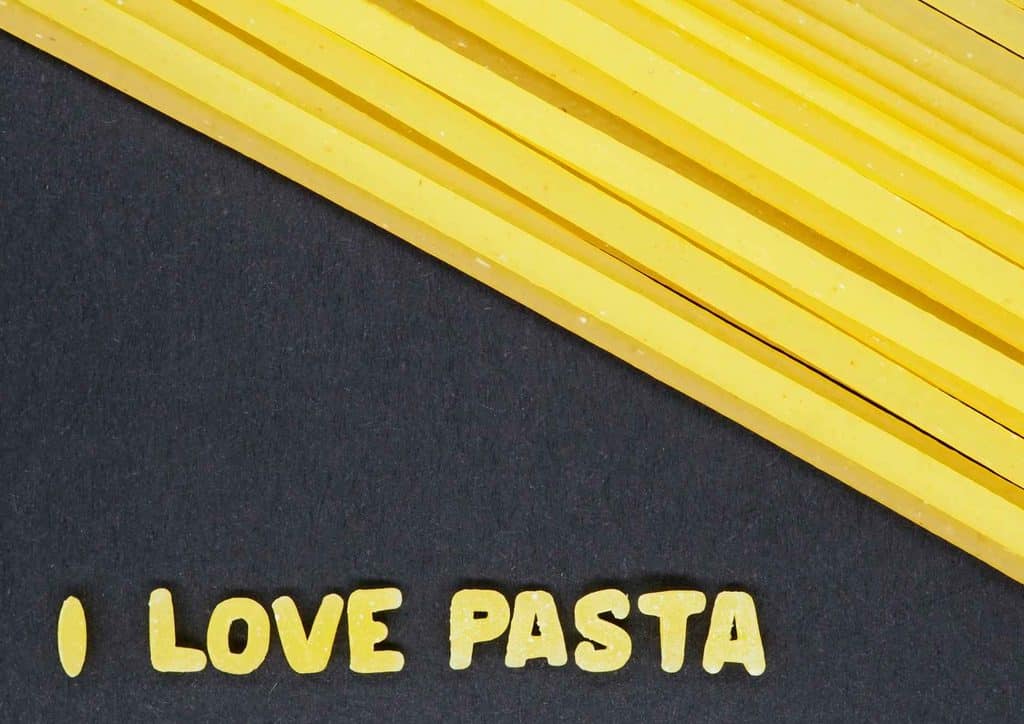 Is Pasta Good for Weight Loss? 18 A plate of pasta on a black background, accompanied by the text "I love pasta" in a stylish font.