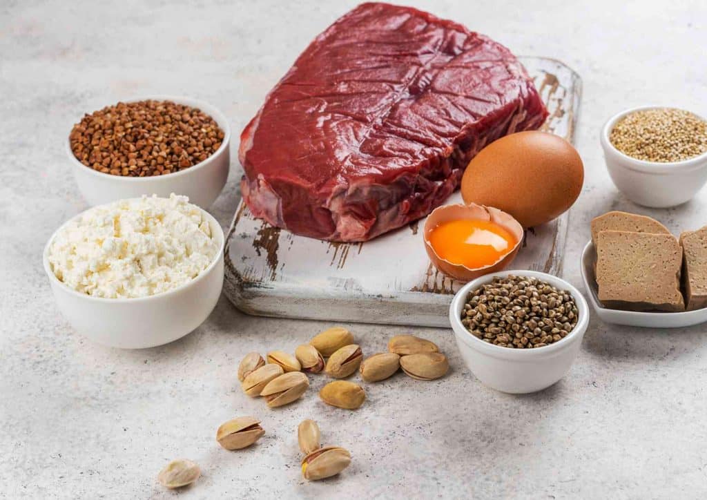 High-Protein Foods for Weight Loss 10 A variety of fresh fruits, vegetables, whole grains, and lean proteins arranged on a wooden table, promoting a healthy diet.