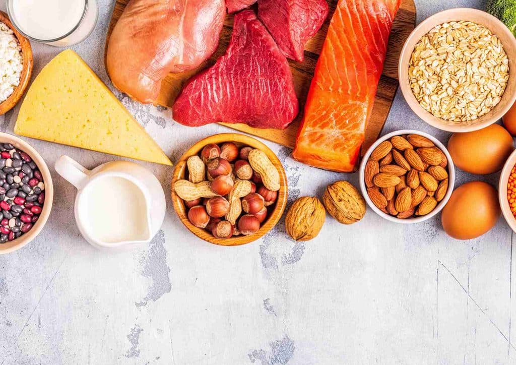 High-Protein Foods for Weight Loss 19 A variety of heart-healthy foods including fruits, vegetables, nuts, and whole grains displayed on a wooden table.