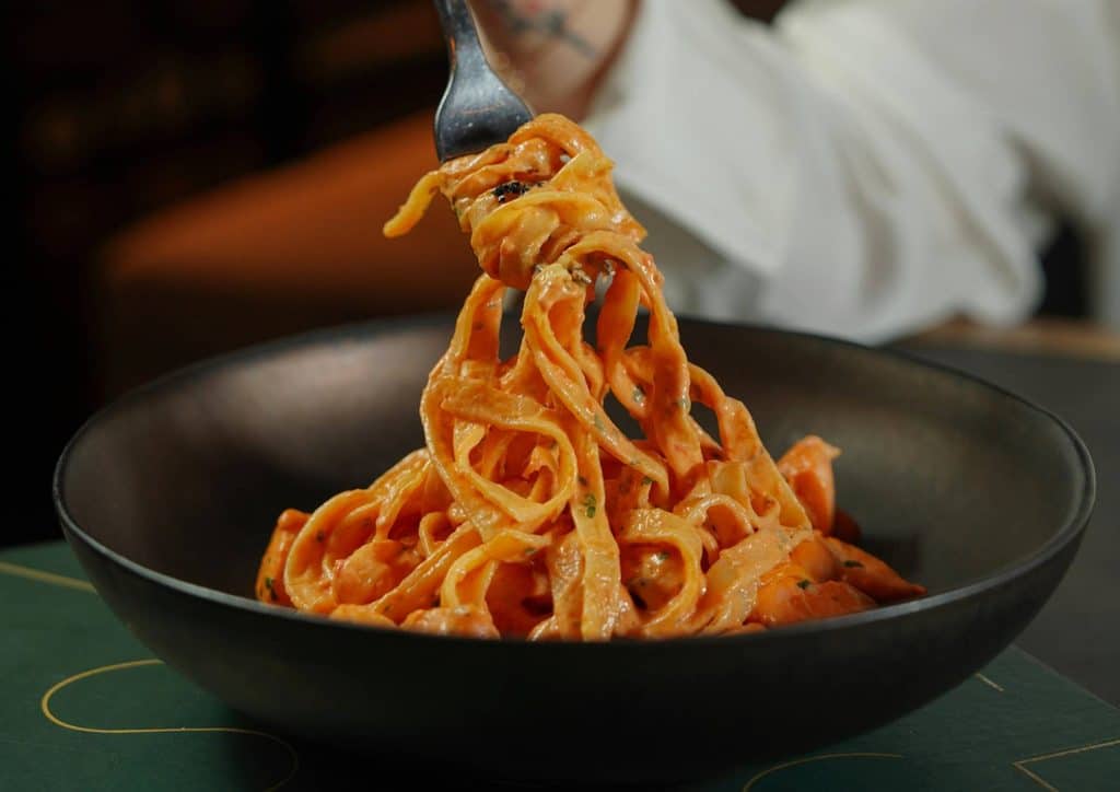 Is Pasta Good for Weight Loss? 22 A person holding a fork above a bowl of pasta, ready to take a bite.