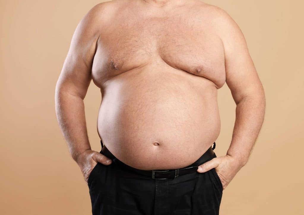 How to Lose Belly Fat: What a Nutritionist Recommends 21 A pregnant woman standing, showcasing her prominent belly with a serene expression on her face.