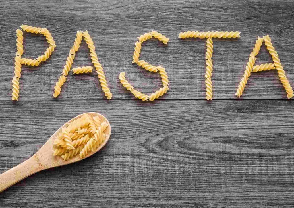 Is Pasta Good for Weight Loss? 20 Pasta arranged to spell the word "pasta" on a rustic wooden table surface.