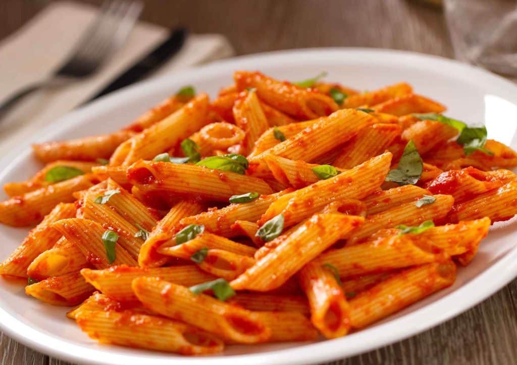 Is Pasta Good for Weight Loss? 23 Penne pasta served with a rich tomato sauce, garnished with fresh basil leaves.