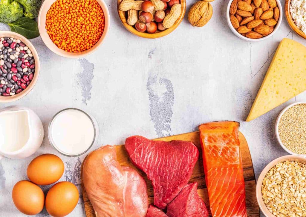 High-Protein Foods for Weight Loss 22 A variety of heart-healthy foods including fruits, vegetables, nuts, and whole grains displayed on a wooden table.