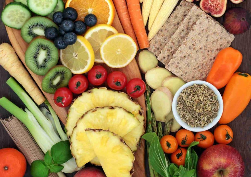 The Best Foods for Weight Loss 29 A colourful assortment of fruits and vegetables neatly arranged on a wooden cutting board.