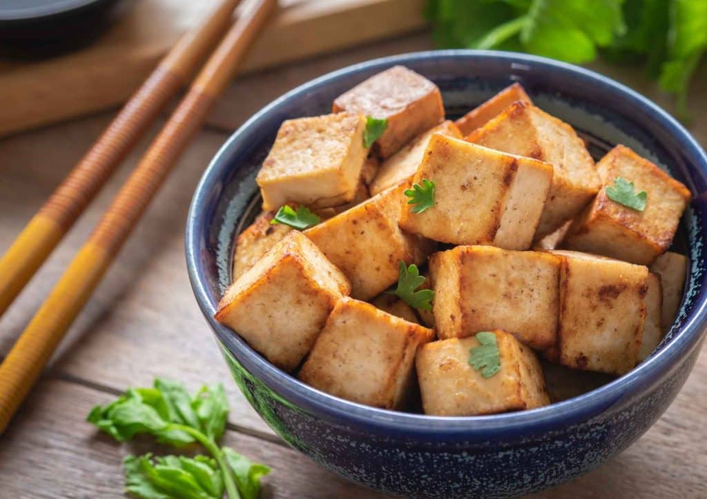 The Best Foods for Weight Loss 9 A bowl of tofu accompanied by chopsticks, showcasing a simple and healthy meal option.