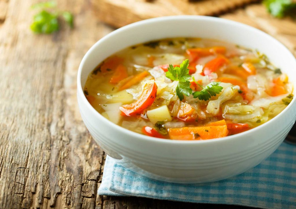 The Best Foods for Weight Loss 12 A bowl of vegetable soup featuring carrots and garnished with fresh parsley.