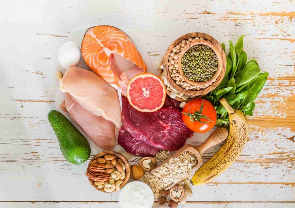 The Best Foods for Weight Loss 8 A colourful assortment of foods featuring fish, meat, vegetables, and fruits arranged on a table.