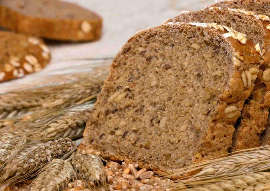 The Best Foods for Weight Loss 20 Sliced bread made with wheat and oats displayed on a wooden table.