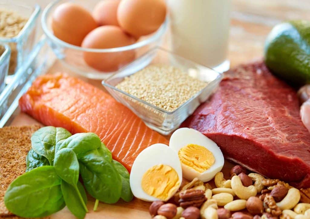 High-Protein Foods for Weight Loss 5 A colourful assortment of fruits, vegetables, whole grains, and lean proteins arranged on a wooden table, promoting healthy eating.