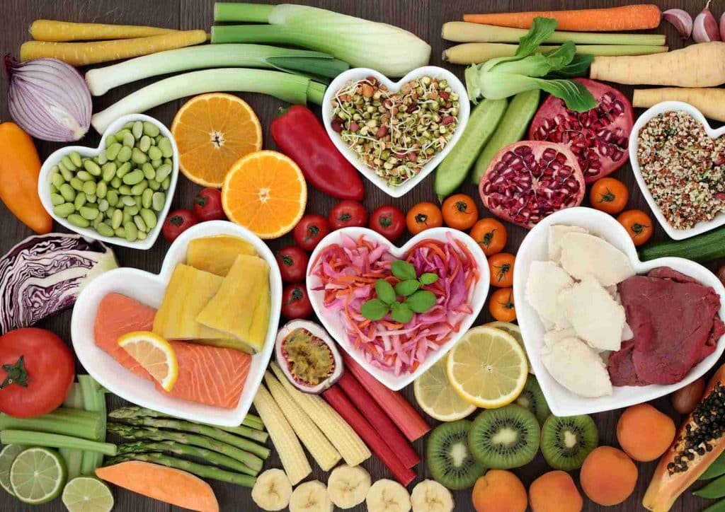 The Best Foods for Weight Loss 22 A heart-shaped arrangement of various fruits and vegetables in colourful bowls, showcasing healthy food options.