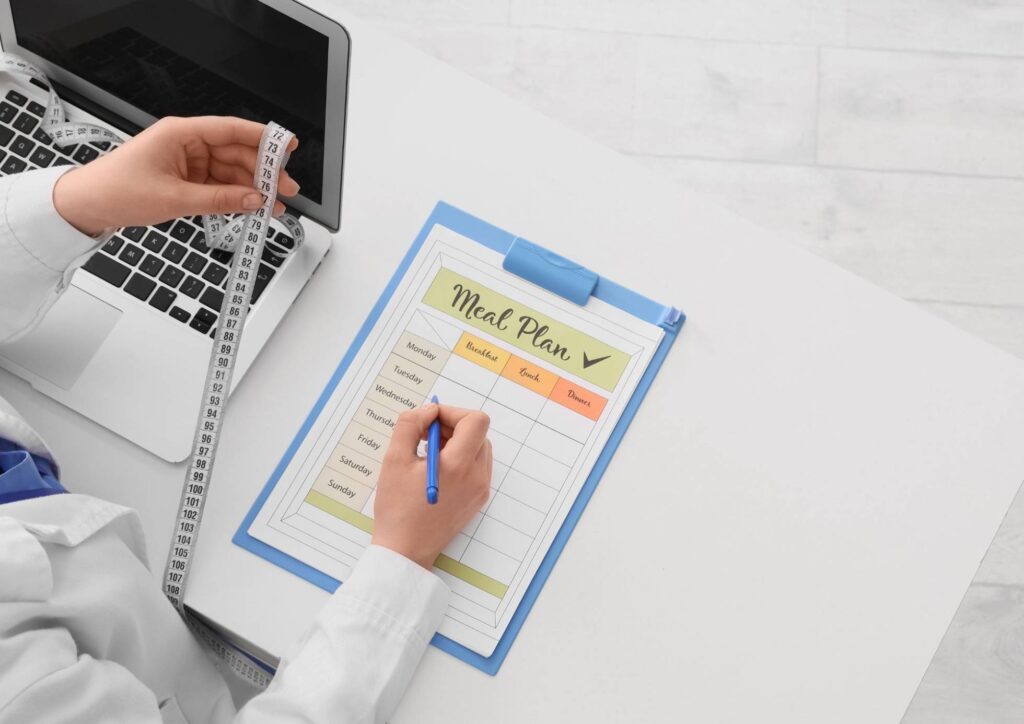 Nutritionist vs Clinical Nutritionist: What's the Difference? 9 A woman measures her height while holding a clipboard, focused on recording her measurement.