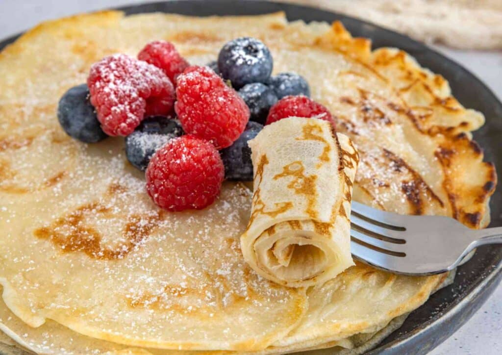 Protein Pancakes Breakfast Recipe for Weight Loss 2 A plate of fluffy pancakes garnished with fresh berries, showcasing a delicious breakfast option.