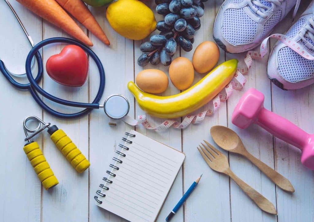 What Is Sustainable Weight Loss? 19 An assortment of healthy foods, including fruits and vegetables, alongside a stethoscope, symbolising health and wellness.