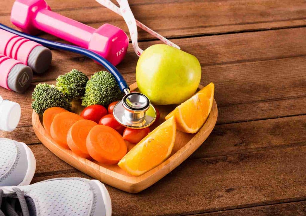 What Is Sustainable Weight Loss? 29 Heart-shaped plate filled with fruits and vegetables, accompanied by a stethoscope, symbolising health and wellness.