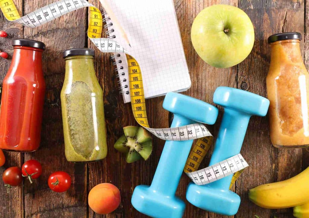 What Is Sustainable Weight Loss? 15 A variety of fruits and vegetables arranged with a measuring tape, symbolising health and nutrition measurement.